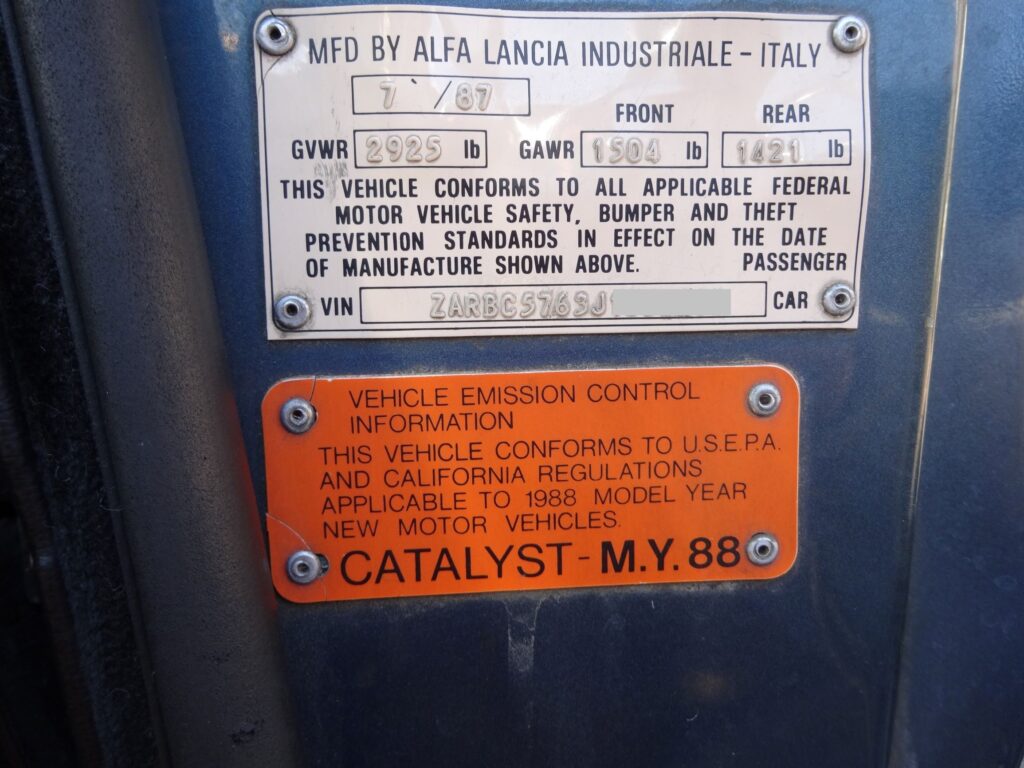 MFD BY ALFA LANCIA INDUSTRIALE- ITALY  FRONT  REAR  GVWR  THIS VEHICLE CONFORMS TO ALL APPLICABLE FEDERAL  MOTOR VEHICLE SAFETY, BUMPER AND THEFT  PREVENTION STANDARDS IN EFFECT ON THE DATE  OF MANUFACTURE SHOWN ABOVE.  • VIN  ZßOC59j6SJf  PASSENGER  CAR  VEHICLE EMISSION CONTROL  S INFORMATION  THIS VEHICLE CONFORMS TO U.S.EPA.  AND CALIFORNIA REGULATIONS  APPLICABLE TO 1988 MODEL YEAR  NEW MOTOR VEHICLES.  @ CATALYST- M.Y. 